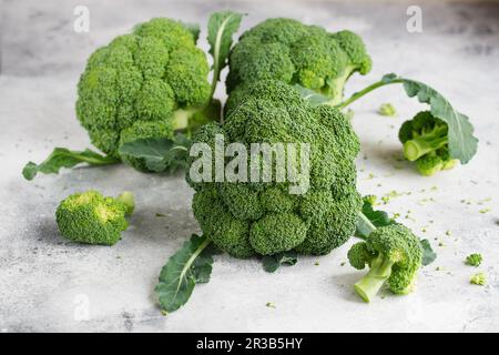 Broccoli freschi verdi su sfondo grigio chiaro. Macrofotografia broccoli di verdure fresche verdi. V verde Foto Stock