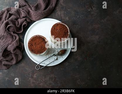 Tiramisù dessert aromatizzato al caffè raggizionale servito in una tazza di vetro sul tavolo Foto Stock