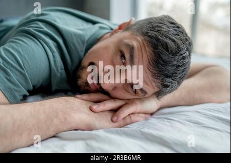 Uomo che si rilassa a letto a casa Foto Stock