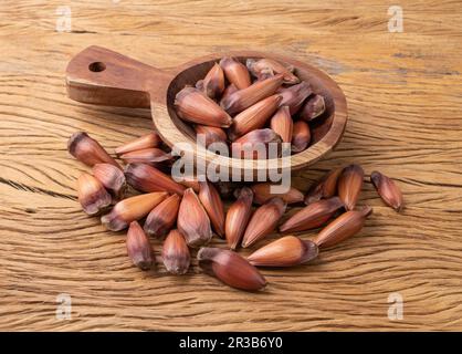 Pignoni o semi di pino su una ciotola su tavola di legno. Foto Stock