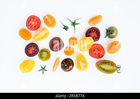 Fette di pomodoro colorate su fondo bianco Foto Stock