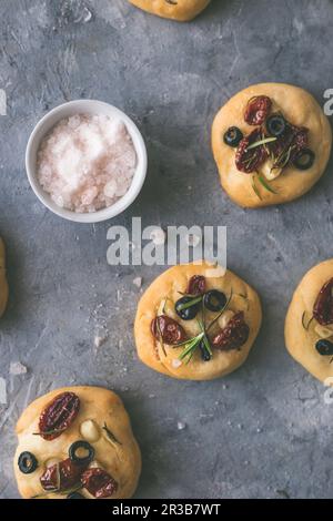 Mini focaccie fresche con pomodori, olive e aglio Foto Stock