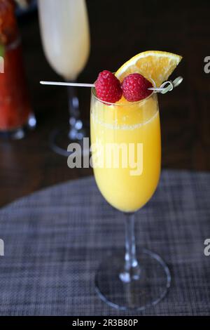 Cocktail Mimosa con contorno di lamponi Foto Stock