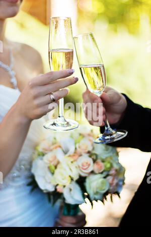 Occhiali da sposa e da poppa per il giorno del matrimonio. Sposa e sposo con bicchieri di champagne clink Foto Stock