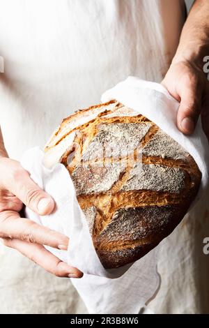 Baker contiene pane appena sfornato Foto Stock
