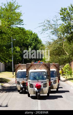 Piccolo TukTuk Grocery Store Home veicoli di consegna in auto attraverso la periferia Foto Stock