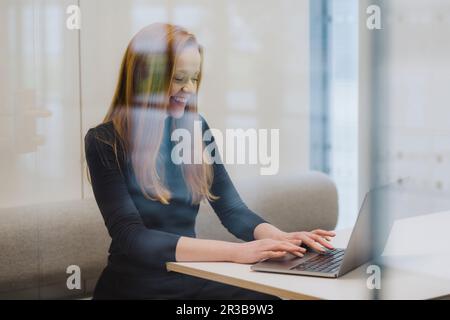 Sorridente imprenditrice lavoro in ufficio armadio elettrico Foto Stock