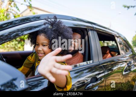 Sorridente figlia godendo viaggio in macchina con padre in macchina Foto Stock