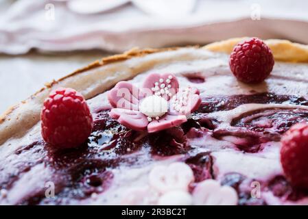 Cheesecake vegana con frutti di bosco e fiori di marzapane Foto Stock