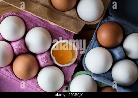 Uova bianche e marroni in scatole di uova, una aperta Foto Stock