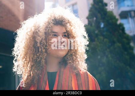 Giovane donna premurosa con capelli ricci Foto Stock