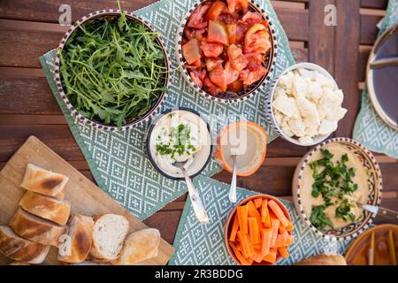 Vari pasti sani in ciotole con prodotti vegani sul tavolo Foto Stock
