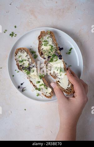 Due fette di pane a pasta madre con burro e crescione Foto Stock