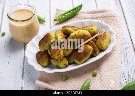 Piselli vegani e crocchette di patate dalla padella con remoulade alle erbe Foto Stock