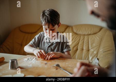 Ragazzo fare gnocchi con padre a casa Foto Stock