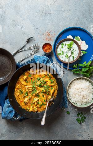 Curry di pollo Keralan in latte di cocco con patate e coriandolo, riso e raita di menta Foto Stock