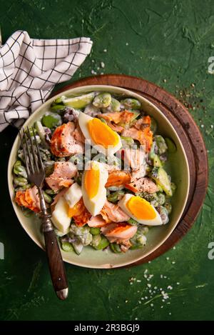 Insalata con fave, cetriolo, olive, salmone, uova e condimento di yogurt greco Foto Stock