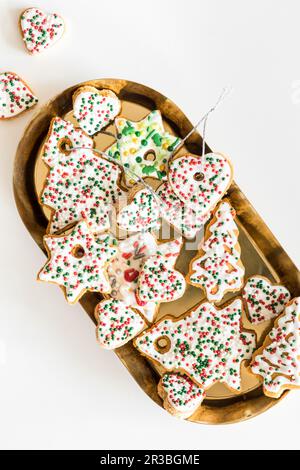 Biscotti di pan di zenzero decorati con spruzzate di zucchero di Natale e glassa reale Foto Stock
