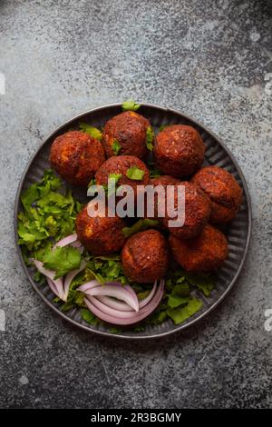 Tradizionale falafel mediorientale servito con coriandolo verde fresco e insalata di cipolle Foto Stock