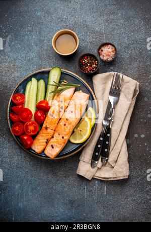 Bistecca di salmone fritto o arrosto con insalata di verdure fresche tagliate Foto Stock