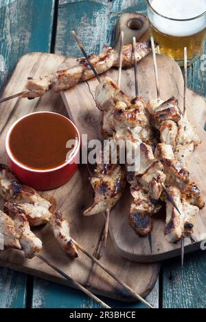 Spiedini di maiale serviti con salsa barbecue e birra Foto Stock