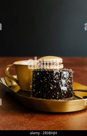 Torta di mousse di cioccolato fondente a specchio decorata con macaron francese Foto Stock