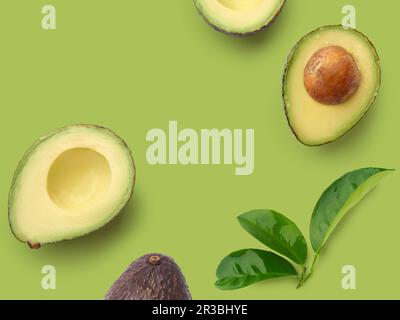 Avocado dimezzato su una superficie verde Foto Stock