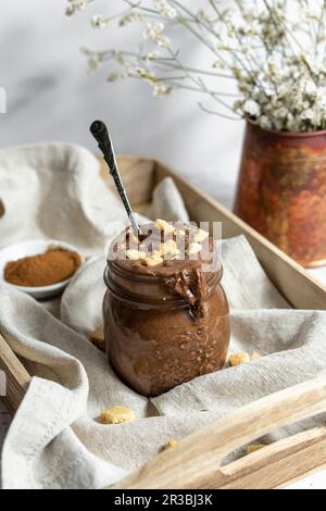 Nocciola di cioccolato senza glutine di Vegan fatta in casa spalmata con cannella e biscotti su un vassoio di legno Foto Stock