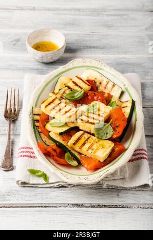 Insalata alla griglia con zucchine, peperoni, pomodori e basilico Foto Stock