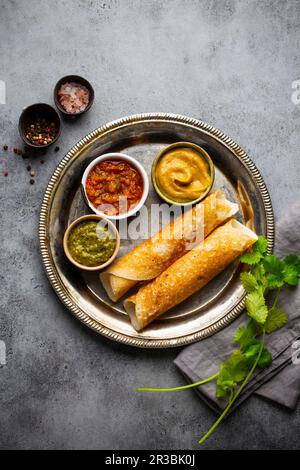 Tradizionale frittelle di riso indiano DOSA con diverse salse chutney e condimenti Foto Stock