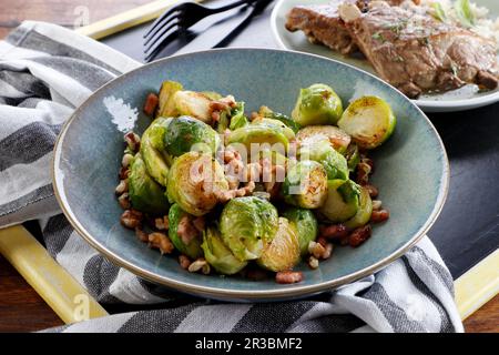 Cavoli di Bruxelles fritti con pancetta e noci Foto Stock