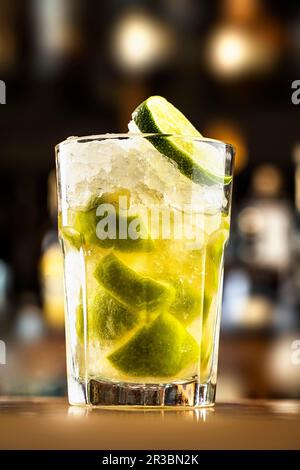 Un cocktail con gelato tritato e fettine di lime in un bicchiere Foto Stock