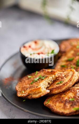Frittelle vegetariane servite con salsa di yogurt Foto Stock