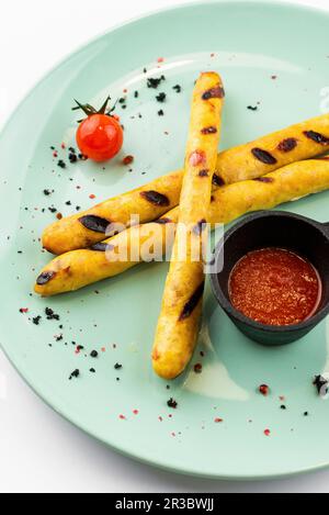 Salsicce tedesche grigliate con salsa di pomodoro calda Foto Stock