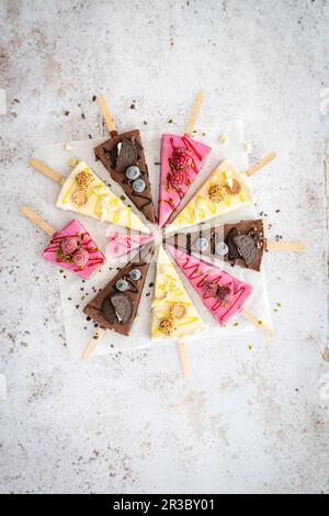 Tre diversi tipi di fette di cheesecake su bastoncini Foto Stock