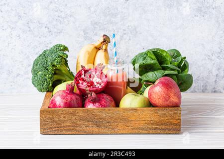 Frutta, verdure, verdure e frullati freschi in vassoio di legno Foto Stock