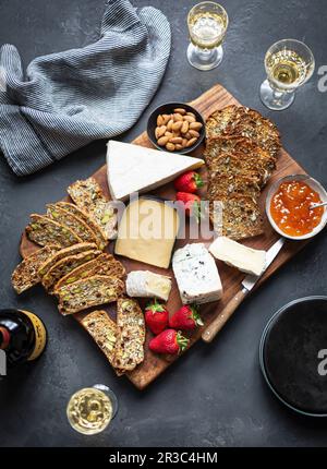 Un piatto di formaggi con pane, fragole e mandorle Foto Stock