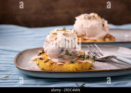 Gelato alle noci vegane con gocce di cioccolato su ananas alla griglia Foto Stock