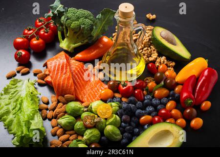 Verdure fresche, insalata verde, frutta, salmone di pesce, noci, mirtilli e olio d'oliva Foto Stock