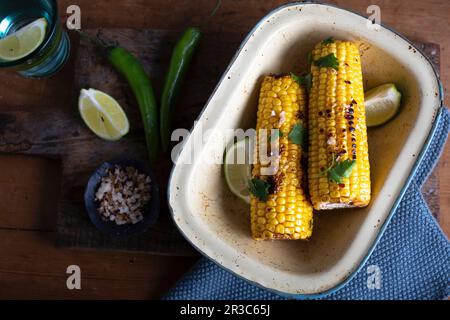 Granoturco alla griglia sulla pannocchia con lime e sale al peperoncino Foto Stock