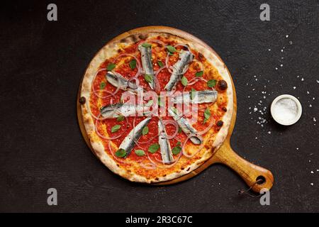 Pizza all'acciuga fresca, cipolla rossa e origano con peperoncino secco Foto Stock