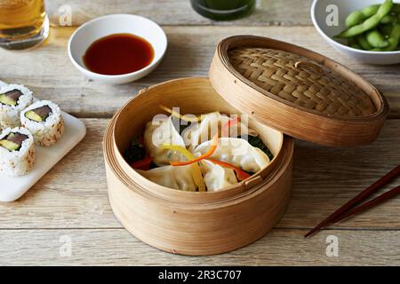 Gyoza (gnocchi giapponesi) con strisce di pepe in un cestino di bambù Foto Stock