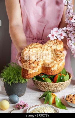 Mani in tenuta Colomba (tradizionale torta di Pasqua italiana con mandorle) Foto Stock