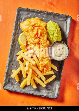 Pesce e patatine con maionese e purea di piselli Foto Stock