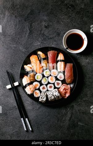 Panini di sushi con salmone fresco, tonno, anguilla e gamberi al riso. Giacitura piatta, spazio di copia Foto Stock