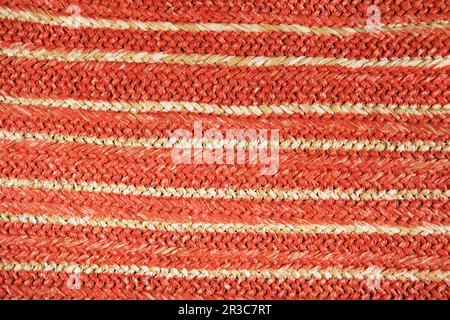 Sfondo colorato con struttura in paglia naturale. Borsa in vimini in paglia intrecciata. Modello di canapa da un sacchetto. Tessitura Foto Stock