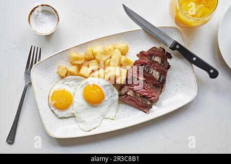 Bistecca con patate e uova fritte Foto Stock