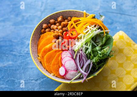 Ciotola vegetariana con ceci, peperoni, foglie di insalata, cipolle e patate dolci Foto Stock
