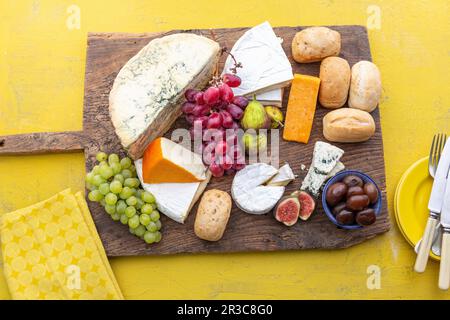 Tagliere di formaggi con panini, fichi, uva e cipolle sottaceto Foto Stock