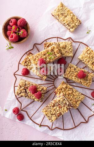 Barrette di marmellata di lamponi con guarnizione a briciola su una griglia di raffreddamento Foto Stock